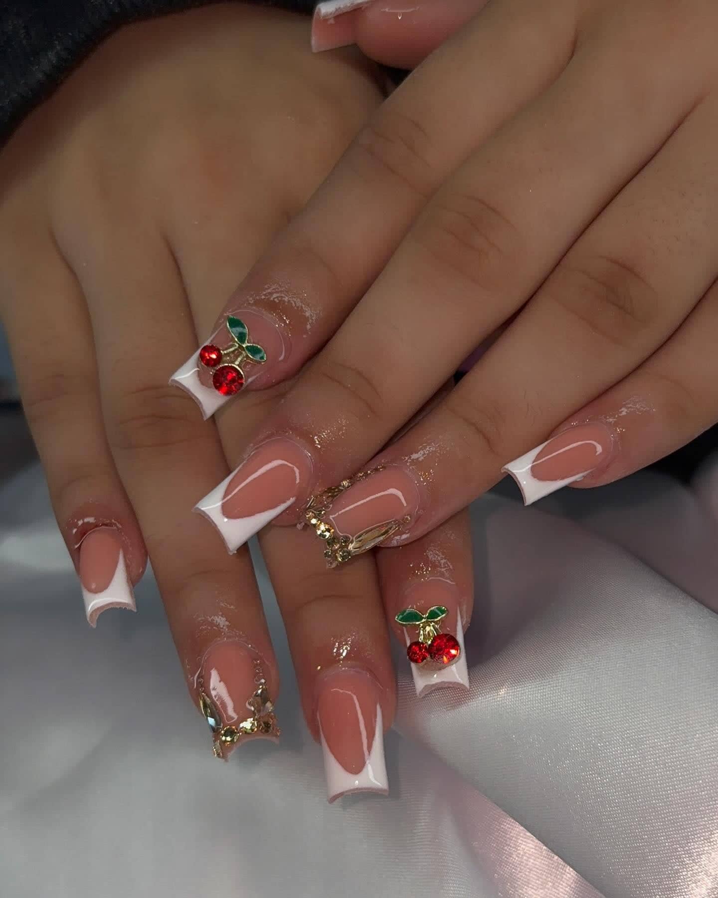 Square nude set with white French tips, red cherry charms and chunky gold charms.