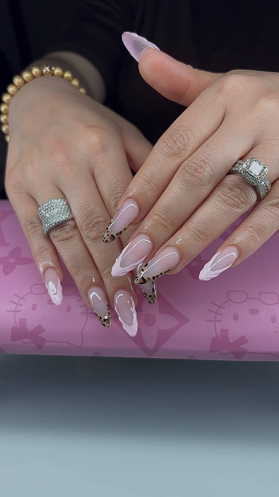 Almond set with sheer pink bases, alternating leopard-print French tips and sculpted lilac 3D French tips.