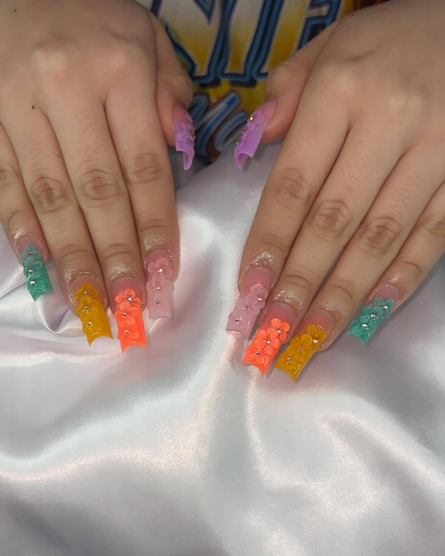 Long square set with jelly French tips in teal, orange, pink and lilac, topped with 3D flowers and rhinestones.