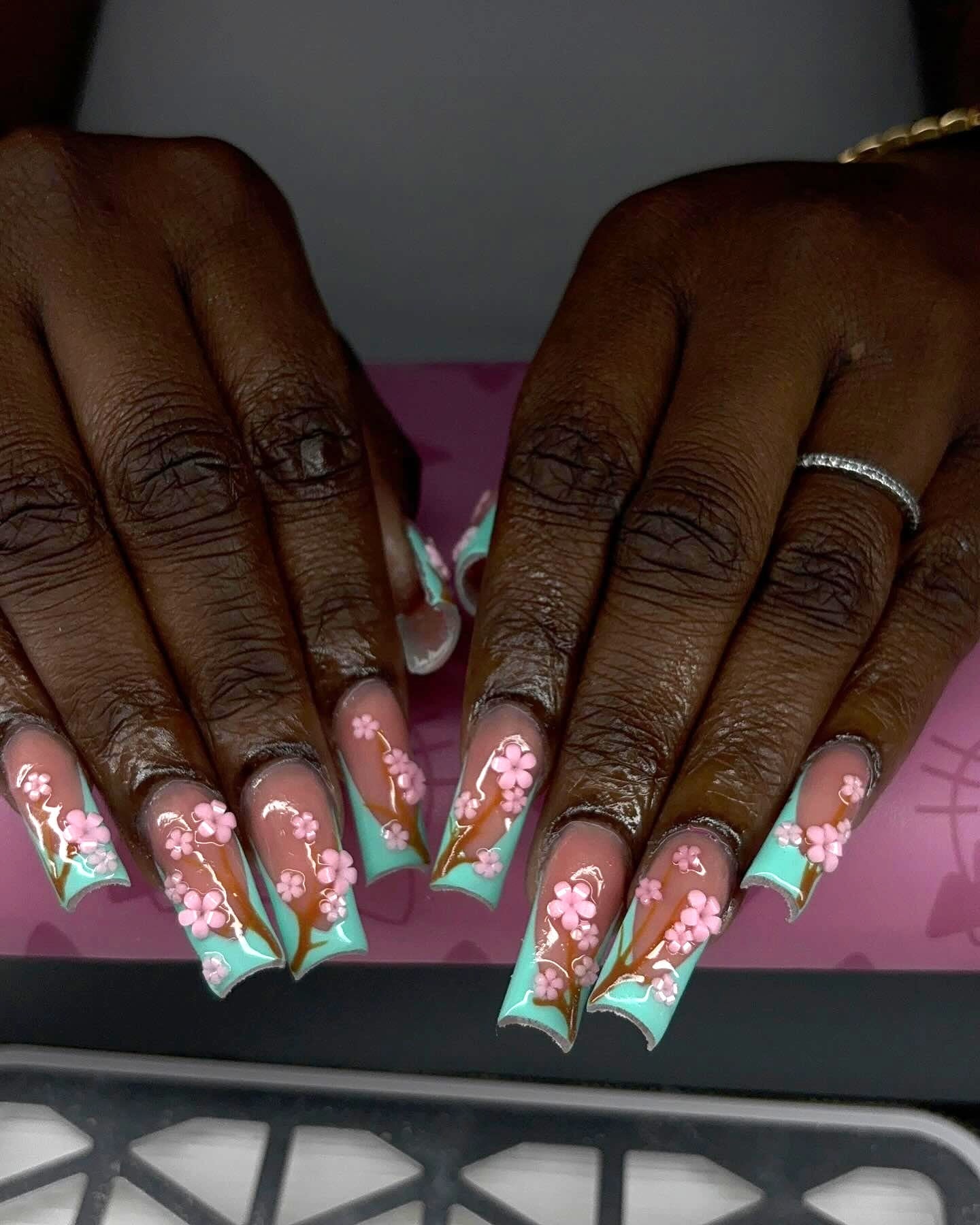 Long square set with mint-green French tips, hand-painted brown branches and pink 3D cherry blossoms.