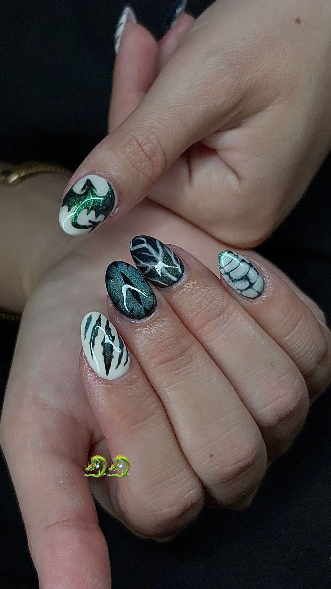 Almond set with hand-painted green and white dragon designs, dragon-scale detailing and a green cat-eye nail.