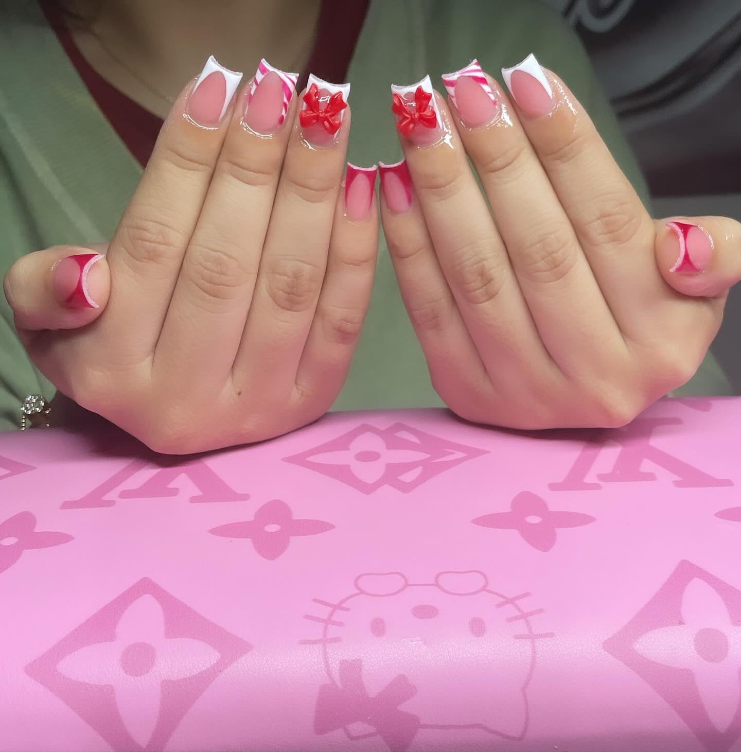Short square set with white and pink French tips, candy-cane stripes and red 3D bows.